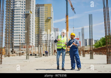 Two engineers discuss work related questions together. Stock Photo