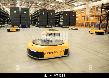 AGV (Automated Guided Vehicle) robots which are responsible for delivering and sorting out parcels work in the electronics logistics base of Chinese o Stock Photo
