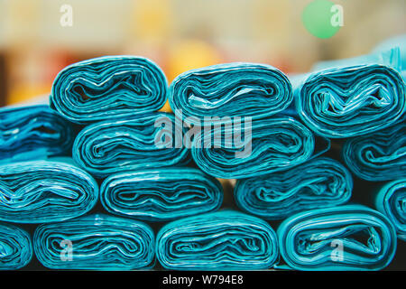 Pile or stack of Blue colored plastic garbage bag container rolls. Blue trash bags. Stock Photo