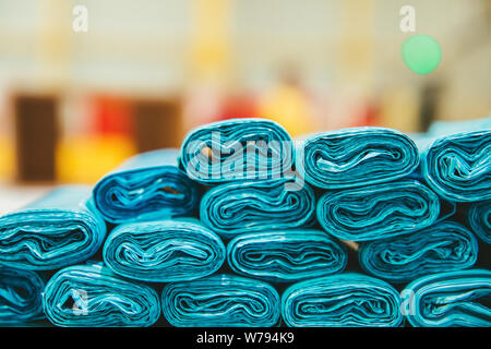 Pile or stack of Blue colored plastic garbage bag container rolls. Blue trash bags. Stock Photo