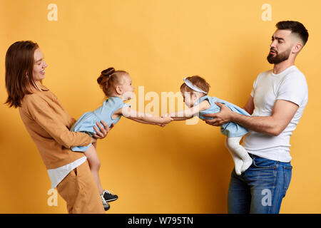 two little female friends doesn't want to go home after playing together.children are being separeted by their parents. strong frindship . isolated ye Stock Photo