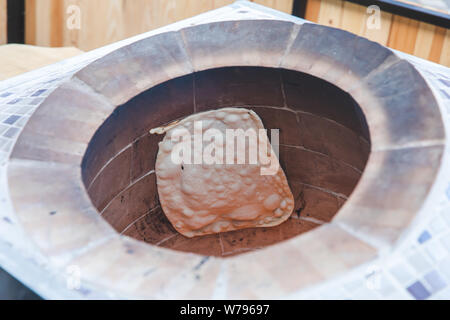 Traditional turkish wood fired stone brick oven and pita or pide bread  dough. This stone oven for Turkish pide or pita bread. Also known as Tandır  or Tandir Stock Photo