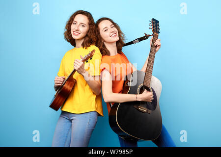 Handsome guy standing holding guitar against the brick wall posing look  away. Relaxing holiday Stock Photo - Alamy