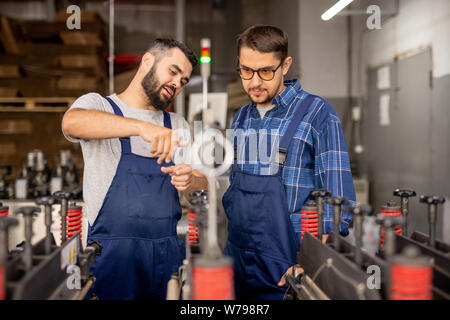 Young engineer explaining his trainee how to serve and use technical equipment Stock Photo