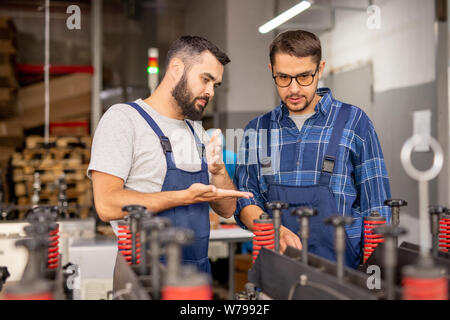 Professional machinery engineer giving instructions to his trainee Stock Photo