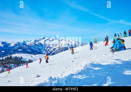 GOSAU, AUSTRIA - FEBRUARY 26, 2019:  The skiers and boarders enjoy their time on snowy slopes of Zwieselalm mount in Dachstein West Alps, on February Stock Photo