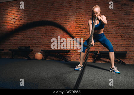 awesome good looking blonde girl doing strength training exercises. full length photo. copy space.girl attends fitness classes Stock Photo