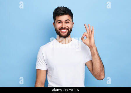 positive attractive Arab young man showing ring gesture with fingers.close up portrait, good job, agreement concept. I am OK, approval. studio shot.gu Stock Photo