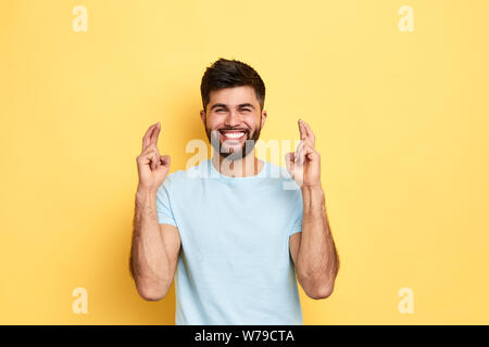 cheerful awesome man wishes good successful business, positive emtion and feeling, body language. close up portrait, isolated yellow background, studi Stock Photo