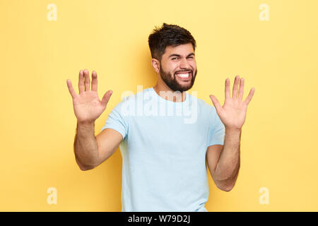 angry frustrated man showing his palms, isolated yellow background, studio shot, guy retracting a claim Stock Photo