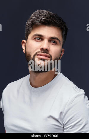 good looking arab in casual clothes guy looking up, rest, leisure time concept. isolated black background, studio shot Stock Photo