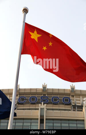 --FILE--A Chinese national flag flutters in front of the headquarters building of COSCO Group in Beijing, China, 30 March 2013.   China's COSCO Shippi Stock Photo