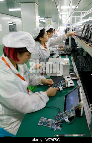 --FILE--Female Chinese workers produce mobile phone parts on the assembly line at a factory in Huaying city, southwest China's Sichuan province, 23 Au Stock Photo