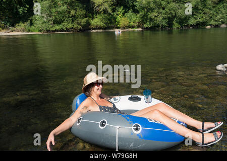 A woman floating on the Santiam River in Oregon, USA. Stock Photo
