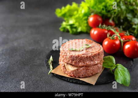 Two raw vegan patties on dark grey background. Copy space Stock Photo
