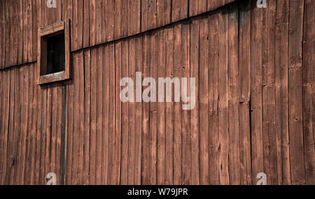 Square hay loft window on side of red barn Stock Photo