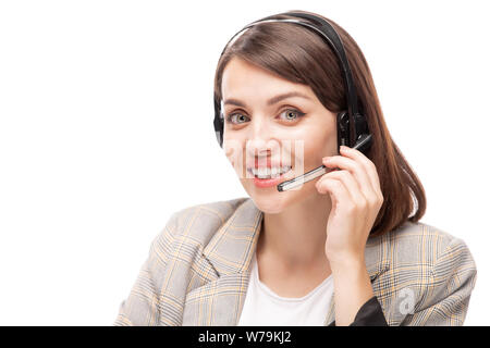 Young smiling hotline consultant in headset answering question of client Stock Photo