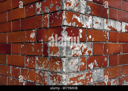 A Close Up Of The Corner Of A Building Faced In Chipped Ceramic Bricks On A Street In London, UK Stock Photo