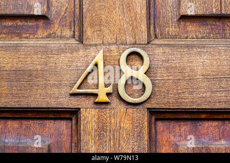 House number 48 on a natural wooden front door Stock Photo
