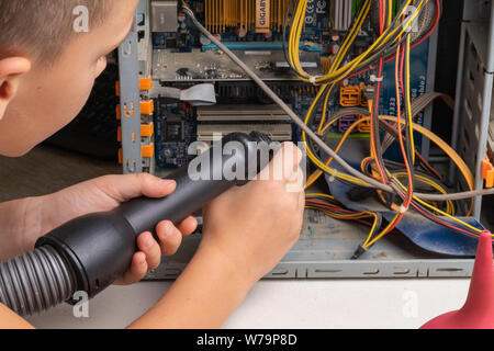 2019.07.17. Odessa. Ukraine. The system unit of a personal computer in dust and cobwebs. Teen boy 10 years old vacuuming computer parts Stock Photo