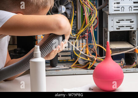 2019.07.17. Odessa. Ukraine. The system unit of a personal computer in dust and cobwebs. Teen boy 10 years old vacuuming computer parts Stock Photo
