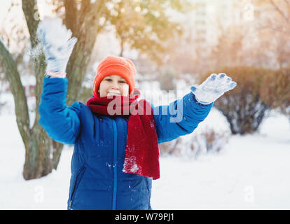 Happy cute excited boy teenager  sledding downhill on a snowy day. winter activity active leisure and entertainment concept. Stock Photo