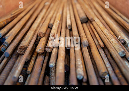 Close up selected focus view stack of straight old rusty high yield stress deformed reinforcement steel or iron bars. Stock Photo
