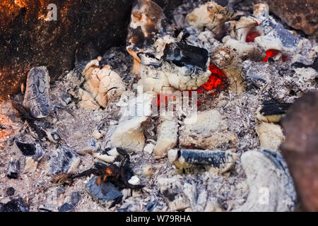 Background of fireplace with gloving embers. Close up view on smouldering fire. Stock Photo