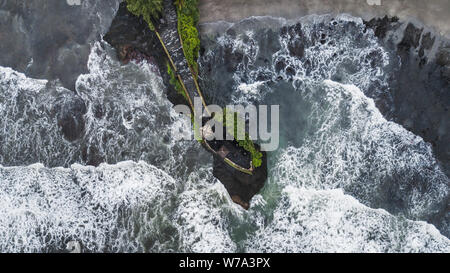 Aerial view of famous balinese temple Tanah Lot in stormy weather with huge crashing waves. Top Indonesian landmark Stock Photo