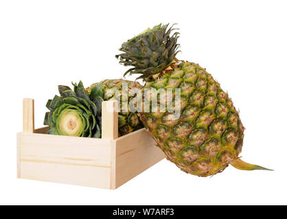 two ripe pineapples in crate isolated on white background Stock Photo