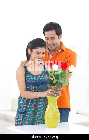 Young man putting on necklace around his wife neck Stock Photo