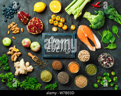 Clean Eating concept. Selection food ingredients and chalkboard with Clean Eating words on dark background. Top view or flat lay. Stock Photo
