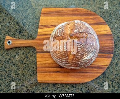 A loaf of white artisan hot bread in a paper bag with transparent ...