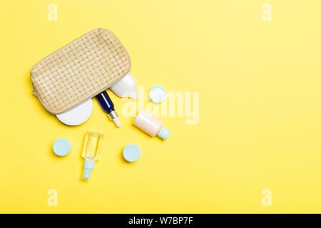 Top view of female cosmetics bag with dropped out cosmetic products on background. Bodycare concept with copy space. Stock Photo