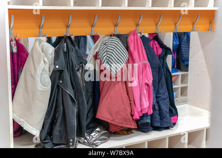 Wardrobe closet full of colorfull clothes in dressing-room. locker room on a hanger hanging clothes Stock Photo