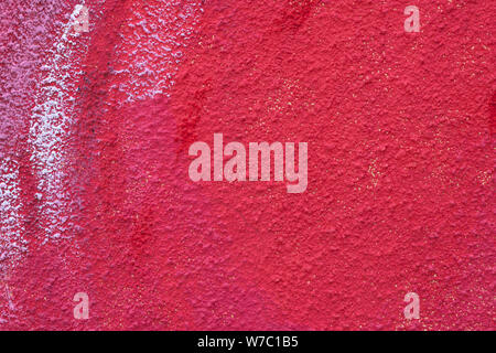 Rough red concrete wall with spots of paint. Old cement cracked texture. Stucco surface. Grunge background. Copy space. Modern paper art close-up. Stock Photo