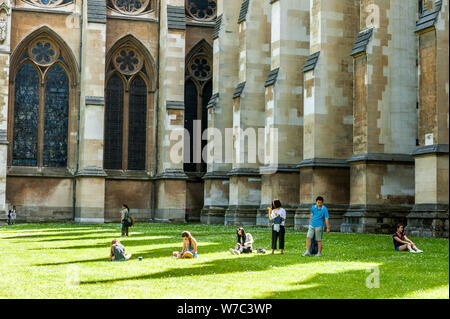 --FILE--Chinese and foreign tourists rest on the lawn in front of the Westminster Abbey in the City of Westminster, London, UK, 23 July 2016.   Ctrip, Stock Photo