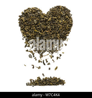 Heart shape made of dry Oolong tea leaves. Tea leaves falling down. Isolated on white background. Stock Photo