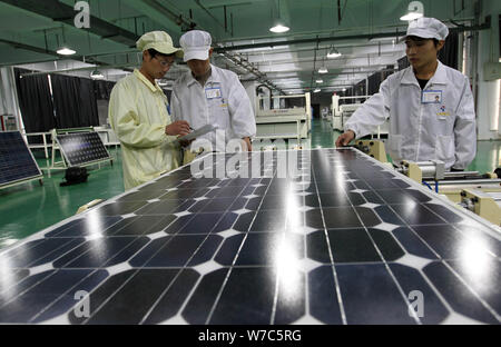 --FILE--Chinese factory workers manufacture solar panels to be exported to the United States at the photovoltaic cell plant of Tianxiang Group in Huai