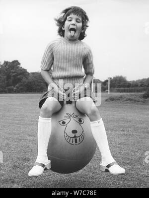 Girl on a space hopper, 1970s. Stock Photo