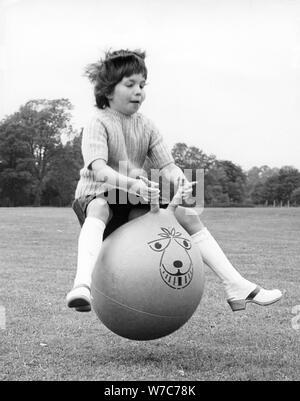 Girl on a space hopper, 1970s. Stock Photo