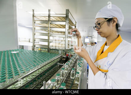 --FILE--A Chinese worker checks infusion bottles on the assembly line ...