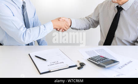 young man shaking hands with an insurance agent or investment adviser  realtor after signing contract document accept agreement making purchase deal i Stock Photo