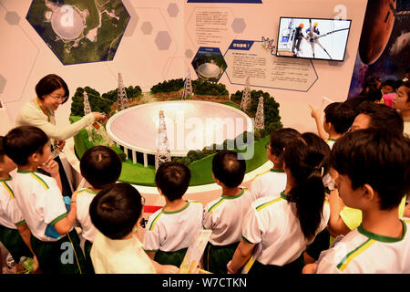 --FILE--People throng to look at the model of the world's largest radio telescope called FAST (Five-hundred-meter Aperture Spherical Telescope) during Stock Photo