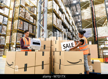 EMBARGOED TO 0001 WEDNESDAY AUGUST 7 EDITORIAL USE ONLY Staff at the Amazon Fulfilment Centre in Peterborough prepare to package and send fax machines to customers as Amazon announce a flash sale of up to 50% on them to celebrate the Premier League transfer deadline day and their first season broadcasting live matches. Stock Photo