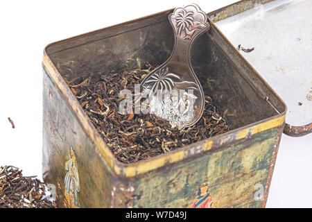 Tealeaves and silver teaspoon in tea tin. Stock Photo