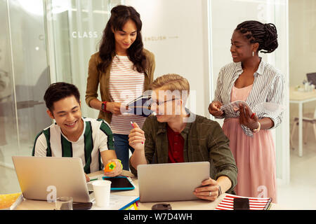Positive delighted young people visiting language course Stock Photo