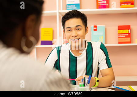 Positive delighted international student answering on question Stock Photo