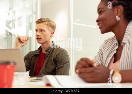 Cheerful dark-skinned girl sitting near her classmate Stock Photo