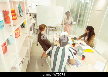Positive delighted young people studying in language school Stock Photo